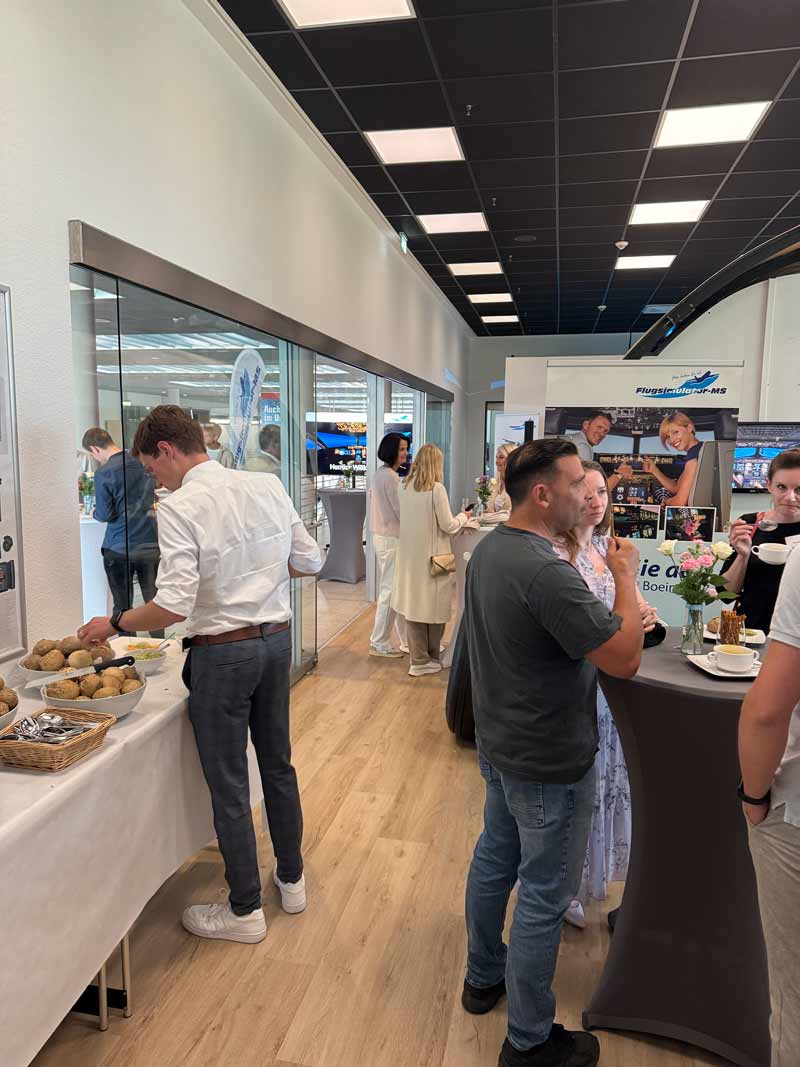 Gäste eines Firmenevents unterhalten sich am Buffet bei Flugsimulator Münster